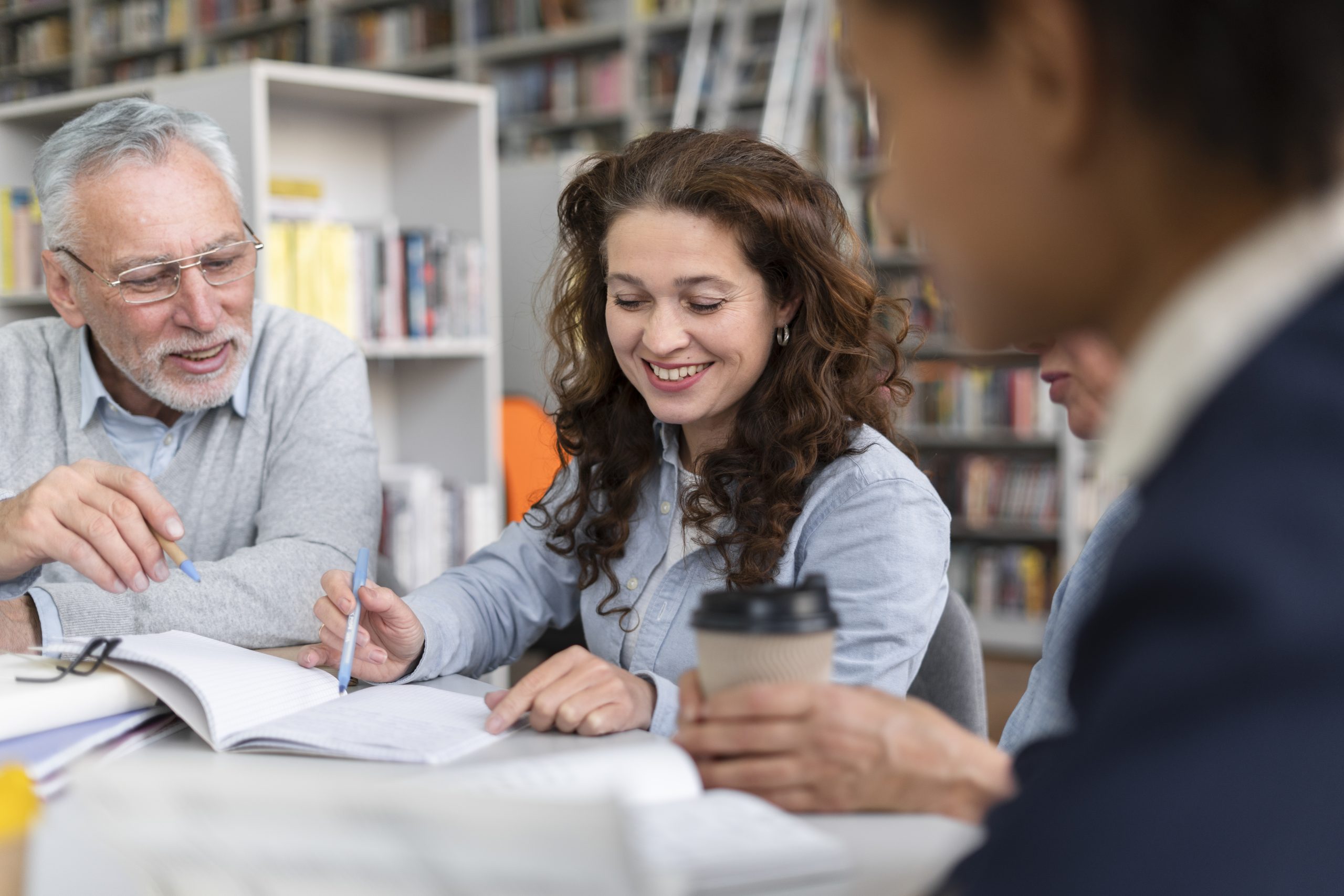 Participants à une formation professionnelle en groupe échangeant autour de supports pédagogiques pour développer leurs compétences RH.